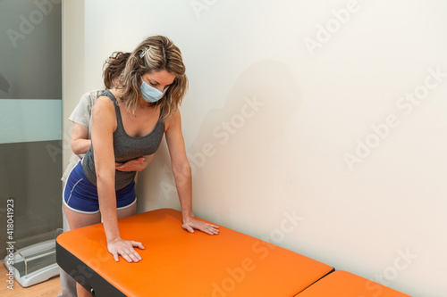 Фотография Physiotherapist and patient in spinal posture correction session, with pandemic protection mask