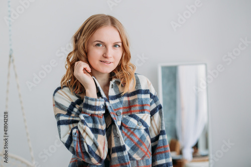 Image of happy young woman posing isolated over home background. Beautiful female looks at camera having her blonde hair. Face expression, feelings and attitude