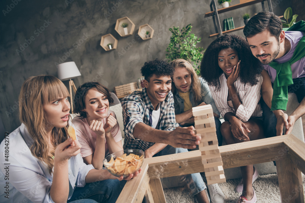 Φωτογραφία Photo portrait of friends playing genga game eating chips laughing excited on ho