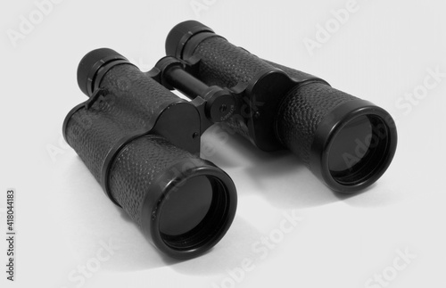 Old black binoculars on a white background