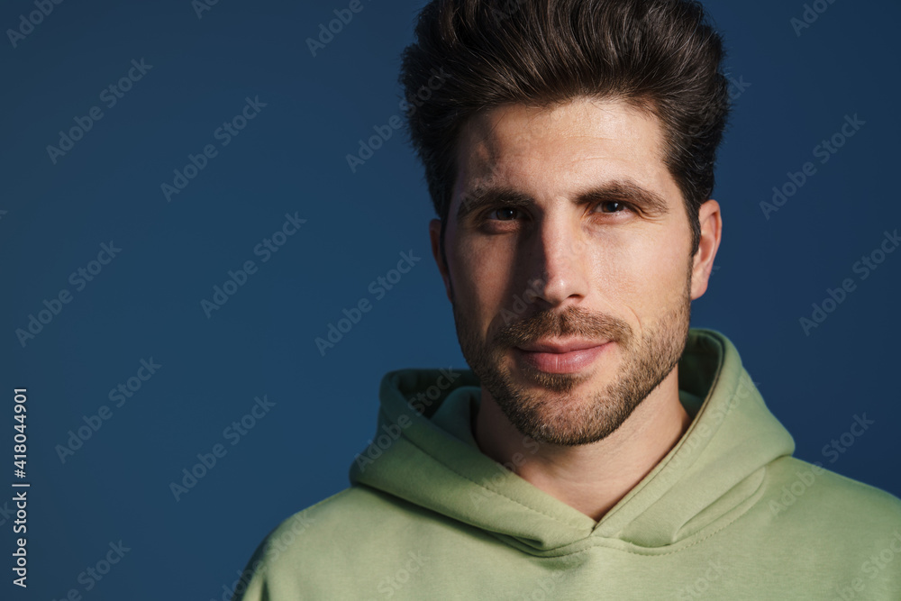 Obraz premium Pleased handsome man in sportswear posing and looking at camera