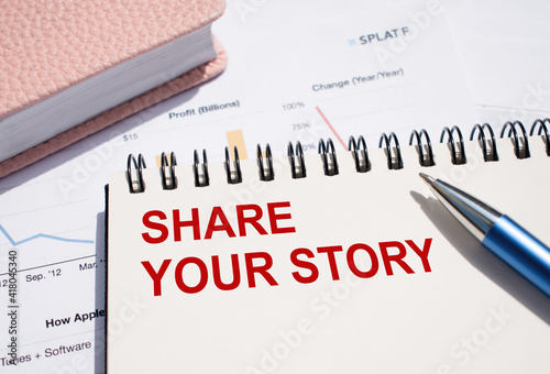 SHARE YOUR STORY. Text written on notepad with pen on financial documents.