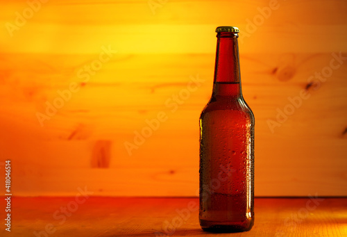 A bottle of cold light beer on a wooden table, copy space
