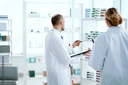 woman and a man are pharmacists discussing new medicines .