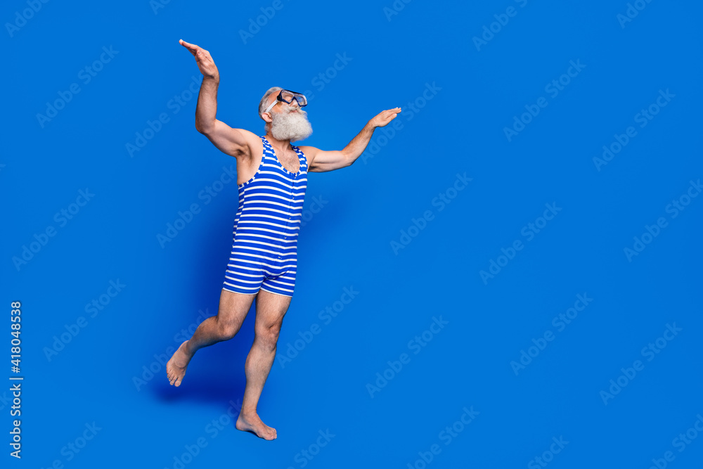 Full size profile side photo of funky funny old man in goggles diving in swimming pool isolated on blue color background