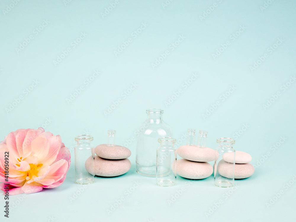 Spa stones, oil bottles and pink flower on white background Spa stones, oil bottles and pink flower on white background