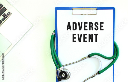 Stethoscope and clipboard with ADVERSE EVENT text on white sheet of paper.