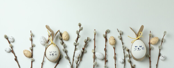 Easter eggs, quail eggs and catkins on white background