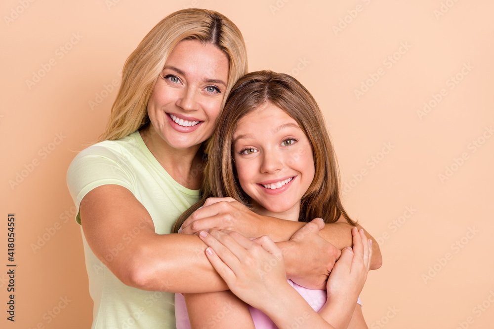 Photo of charming lady hugging adorable pupil toothy smile enjoy weekend isolated on beige color background Photo of charming lady hugging adorable pupil toothy smile enjoy weekend isolated on beige color background