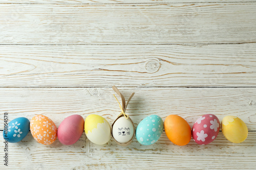 Bunny made of egg and Easter eggs on wooden background