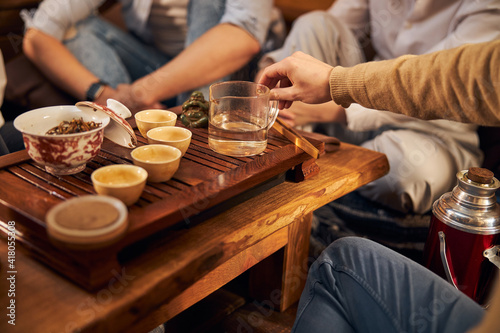 Young man performing traditional tea ceremony in cozy cafe