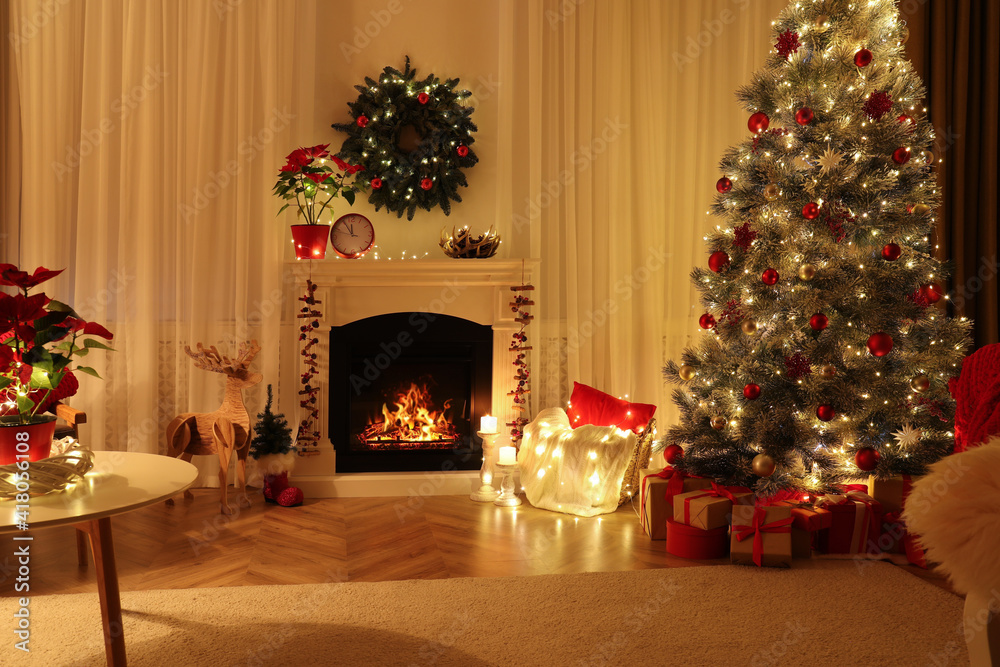 Beautiful living room interior with burning fireplace and Christmas tree in evening