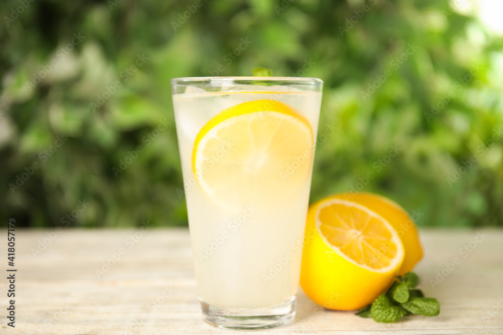 Cool freshly made lemonade in glass on white table