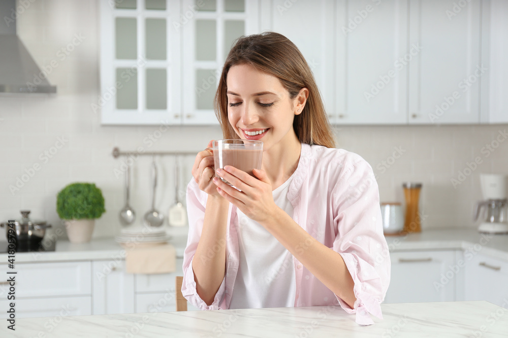 Young woman drinking chocolate milk in kitchen Young woman drinking chocolate milk in kitchen