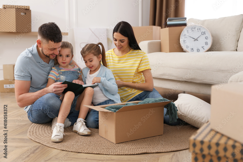 Happy family unpacking moving box at their new house Happy family unpacking moving box at their new house