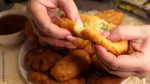 A woman's hands break a freshly baked pie in half.
