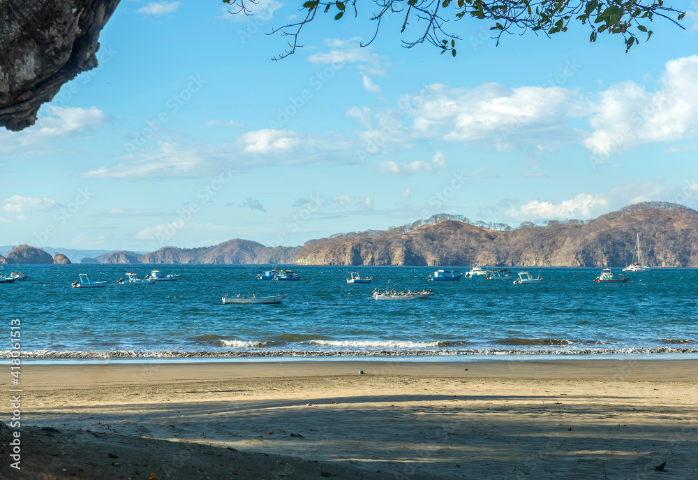 Fishing boats on the ocean with amazing landscape. Playa Hermosa, Guanacaste - Costa Rica. Central America.