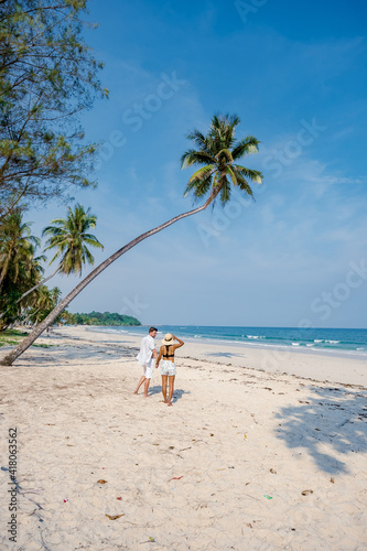 couple on vacation in Thailand, Chumpon province, white tropical beach with palm trees, Wua Laen beach Chumphon area Thailand, palm tree hanging over the beach with a couple on vacation in Thailand. photo