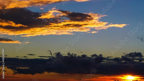 Timelapse 4K. Fast-moving dramatic thick clouds at sunset.