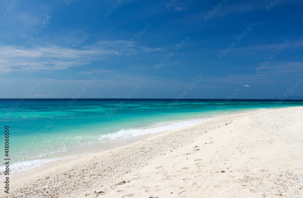 sandy beach with turquoise sea water and bright blue sky