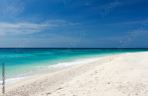 sandy beach with turquoise sea water and bright blue sky