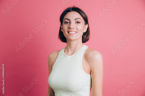 Woman on pink background happy face smiling looking at the camera. Positive person.