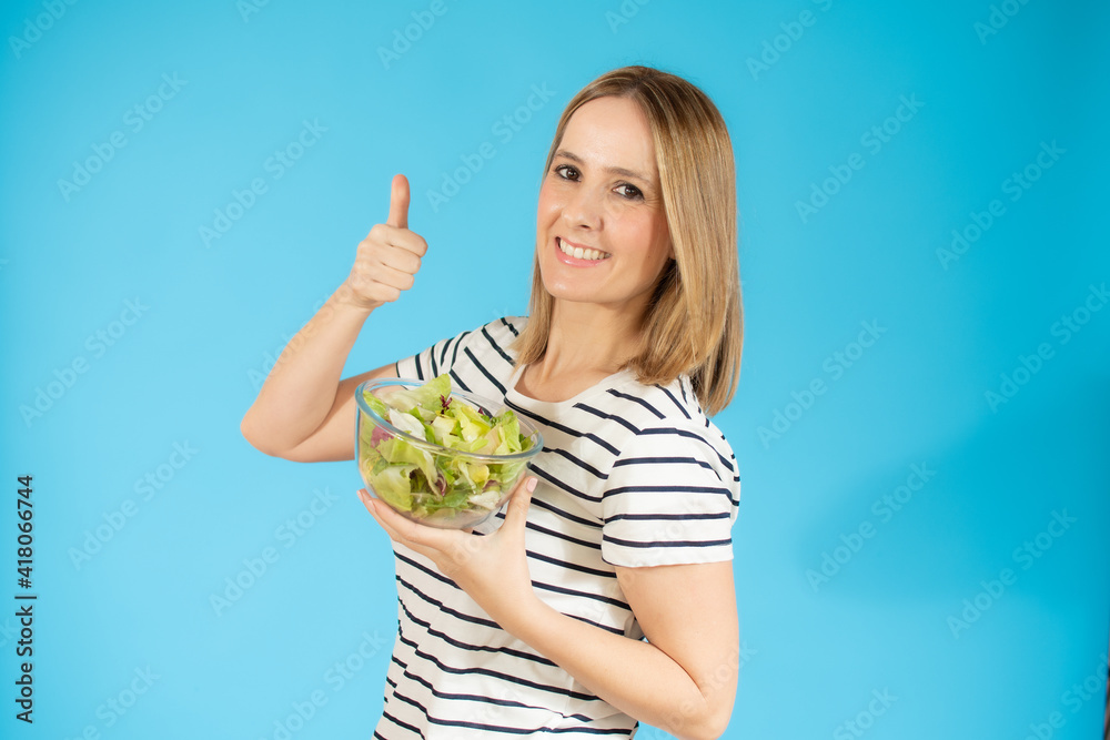 Woman diet concept portrait. Young woman holding green salad. Isolated portrait. Woman diet concept portrait. Young woman holding green salad. Isolated portrait.