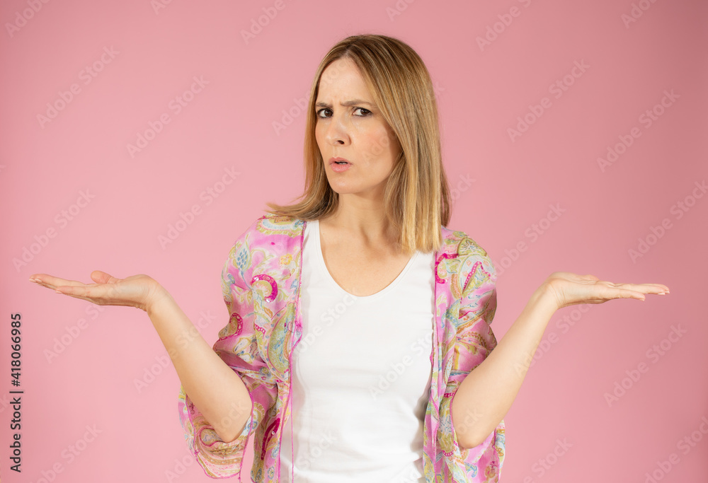 Young woman standing over pink isolated background clueless and confused expression with arms and hands raised. Doubt concept. Young woman standing over pink isolated background clueless and confused expression with arms and hands raised. Doubt concept.