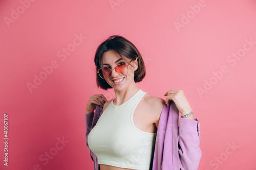 Young cute  women casual wear sunglasses on pink background happy active moving dancing jumping © Анастасия Каргаполов