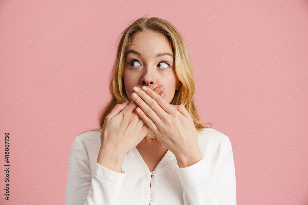 Cheerful young blonde woman covers mouth with palms Cheerful young blonde woman covers mouth with palms