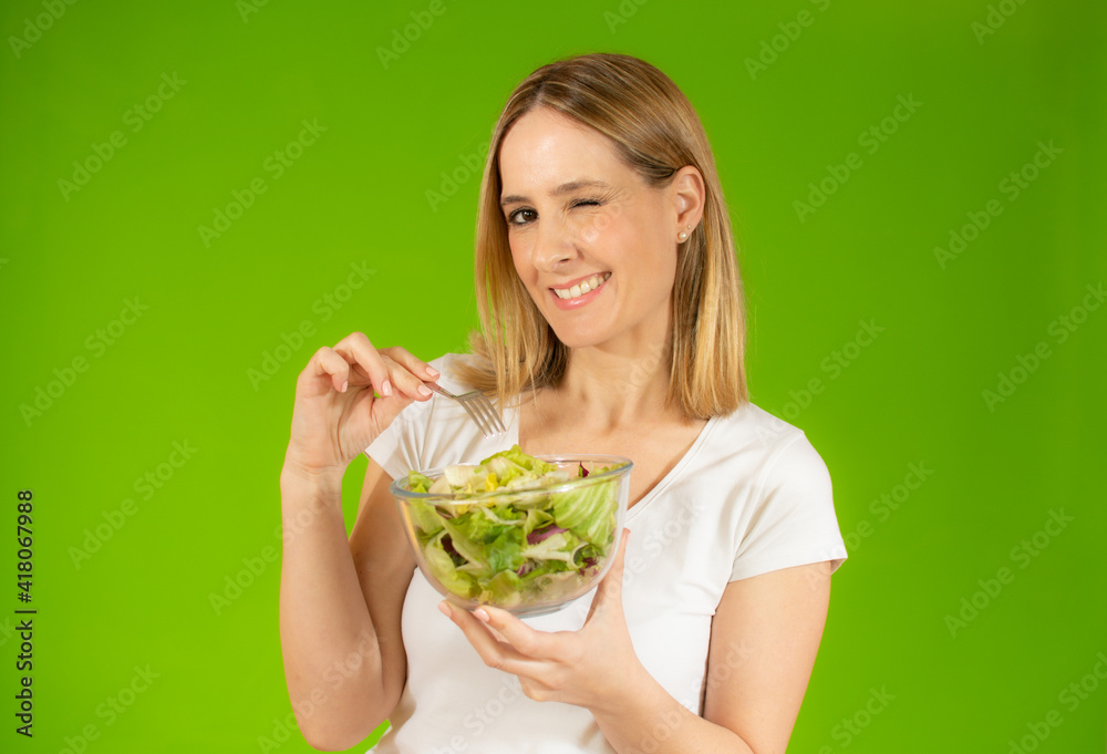 Woman diet concept portrait. Young woman eating green salad. Isolated portrait. Woman diet concept portrait. Young woman eating green salad. Isolated portrait.