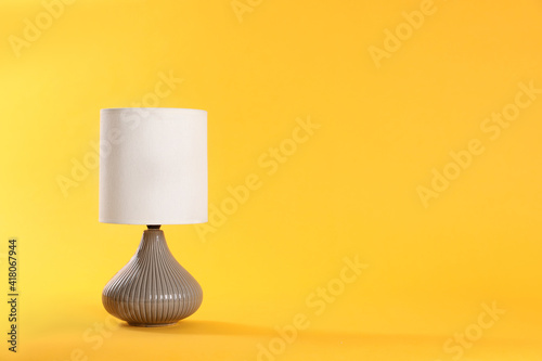 Stylish new night lamp on yellow background. Space for text