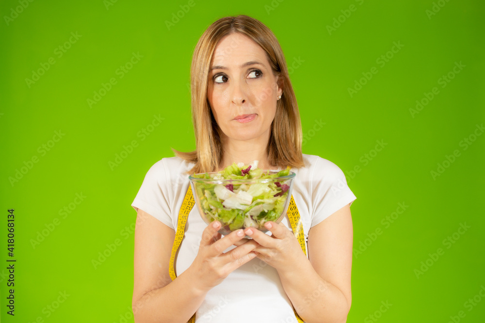 Woman diet concept portrait. Young woman hold green salad. Isolated portrait. Woman diet concept portrait. Young woman hold green salad. Isolated portrait.