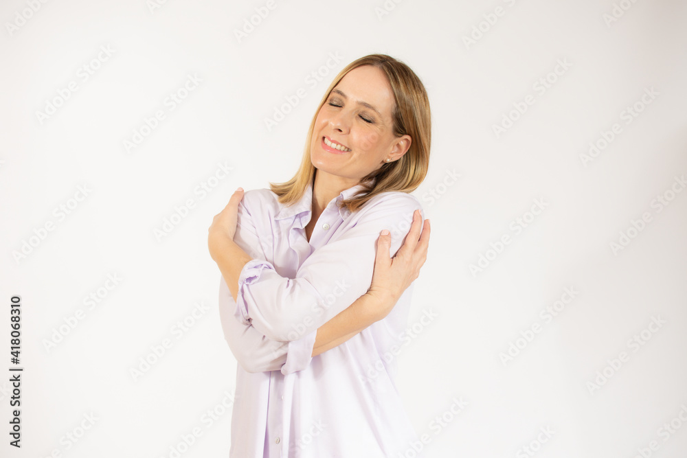 Portrait of a pretty young woman in casual shirt hugging herself. Concept of selfish emotion. Portrait of a pretty young woman in casual shirt hugging herself. Concept of selfish emotion.