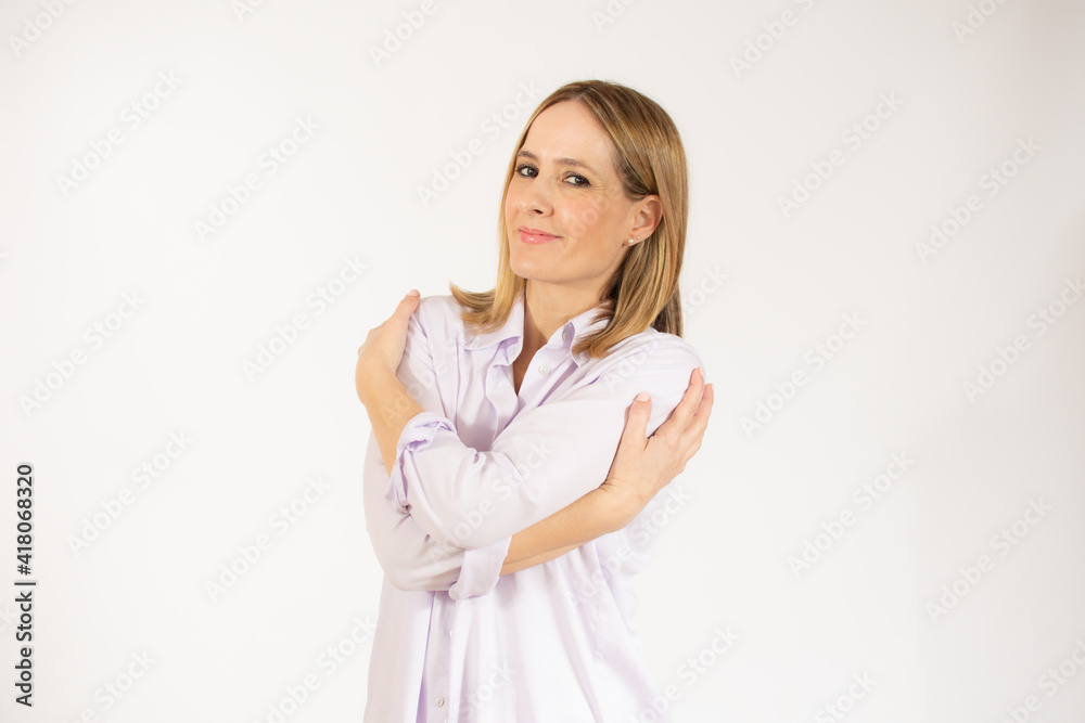 Portrait of a pretty young woman in casual shirt hugging herself. Concept of selfish emotion. Portrait of a pretty young woman in casual shirt hugging herself. Concept of selfish emotion.