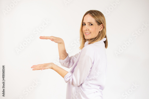 Beautiful young woman holding something over white background