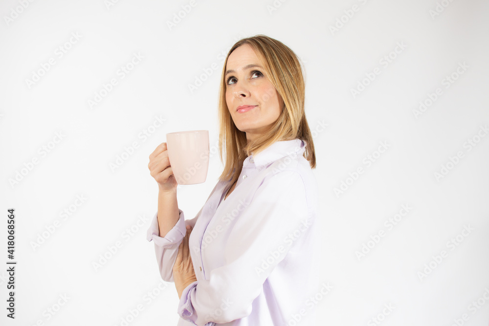 Young smiling woman drinking a cup of hot coffee over isolated white background Young smiling woman drinking a cup of hot coffee over isolated white background