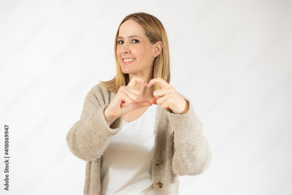 Portrait of smiling young woman making heart form with her hands smiling wearing casual clothes isolated over white background Portrait of smiling young woman making heart form with her hands smiling wearing casual clothes isolated over white background