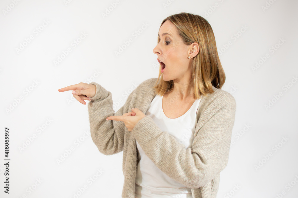 Young woman over isolated white background pointing fingers to the side Young woman over isolated white background pointing fingers to the side