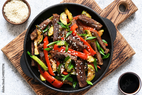 Frying pan with vegetables and beef and sesame seeds. Asian food.