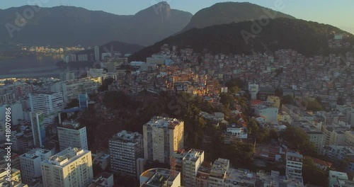 Aerial move towards Cantagalo hilltop favela set amongst luxury apartment buildings and Rio de Janeiro's natural mountains photo