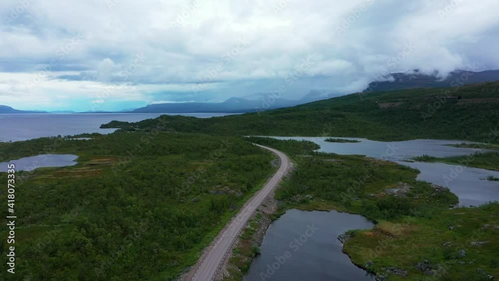 Aerial view of of road E10, lake Tornetrask and the Lapporten mountains, dark, cloudy day, in Northern Sweden - descending, drone shot Aerial view of of road E10, lake Tornetrask and the Lapporten mountains, dark, cloudy day, in Northern Sweden - descending, drone shot