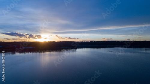 Aerial view of a beautiful and dramatic sunset over a forest lake reflected in the water  landscape drone shot. Blakheide  Beerse  Belgium. High quality photo