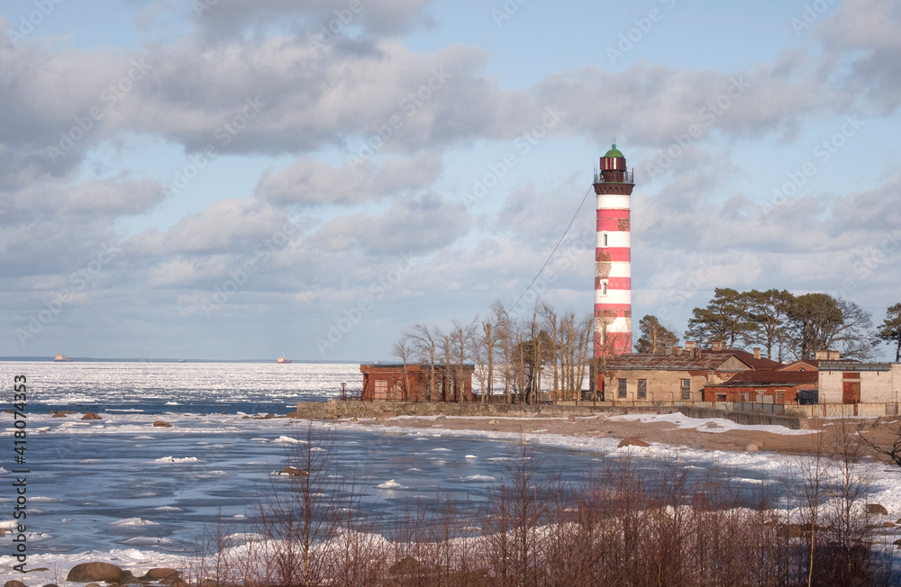 The old Shepelevsky lighthouse on the shores of the Baltic Sea on a sunny day in early spring.