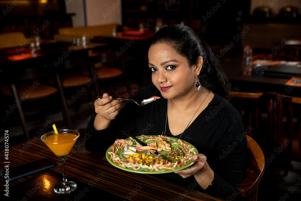 Portrait of a pretty woman eating delicious food in a restaurant.