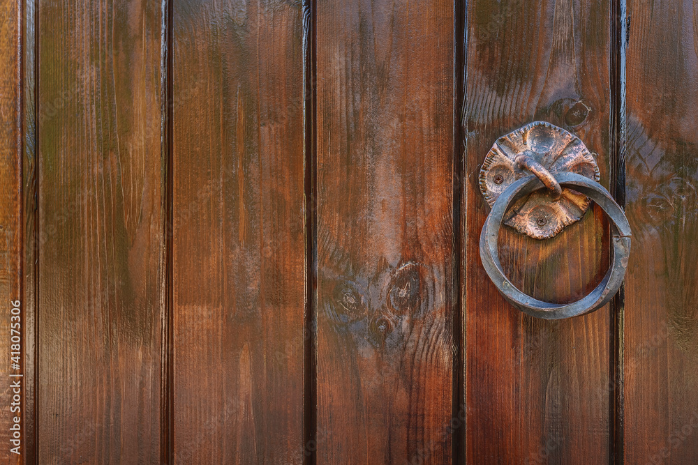 Wooden door with wrought iron handles. Sash of old doors. Wooden gate up close Wooden door with wrought iron handles. Sash of old doors. Wooden gate up close
