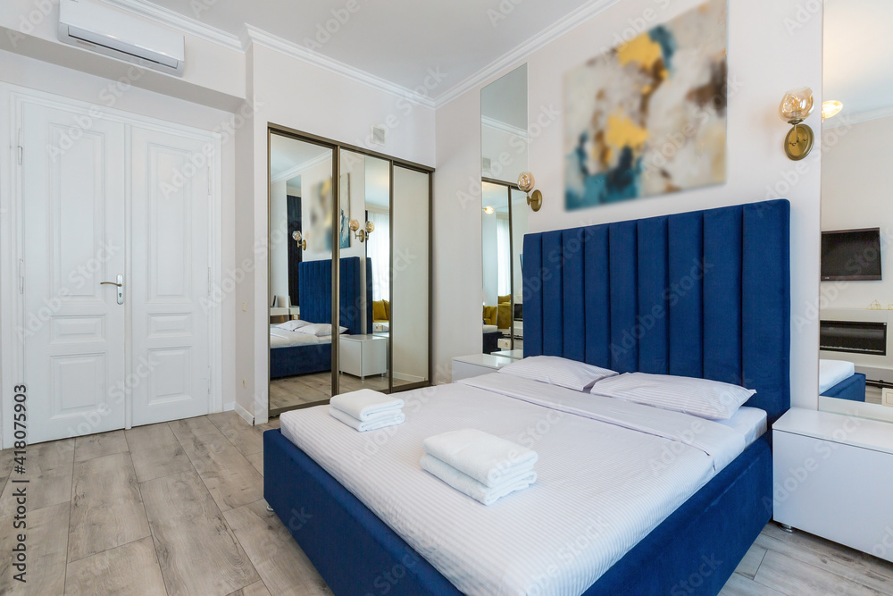 Interior photography, large bedroom in a modern loft style, with a double bed and a yellow sofa Interior photography, large bedroom in a modern loft style, with a double bed and a yellow sofa
