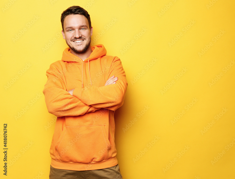 Smiling man standing against yellow background Smiling man standing against yellow background