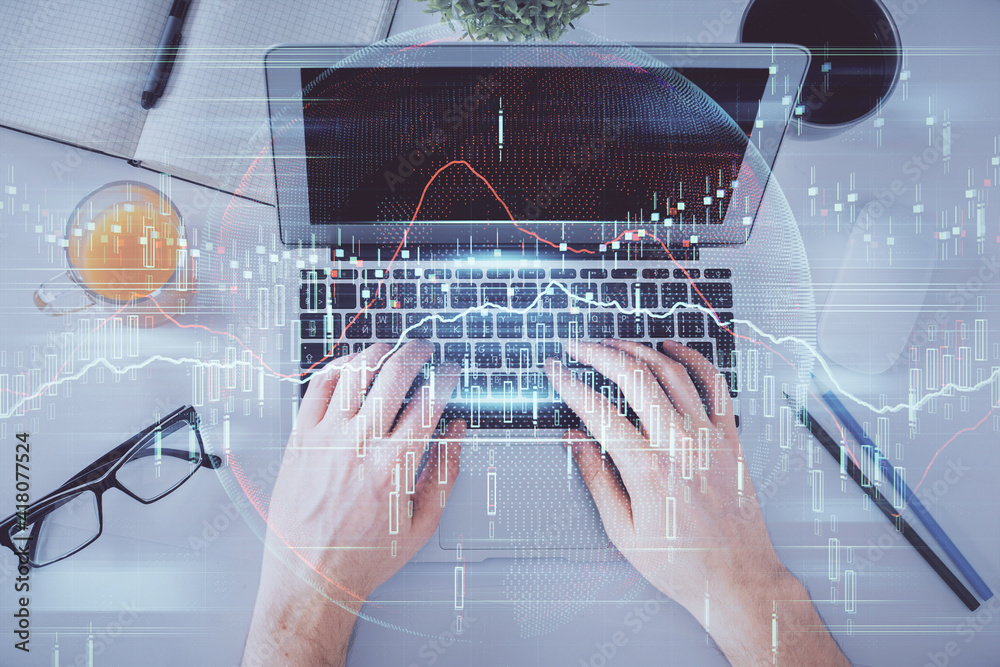 Double exposure of man's hands typing over laptop keyboard and forex chart hologram drawing. Top view. Financial markets concept. Double exposure of man's hands typing over laptop keyboard and forex chart hologram drawing. Top view. Financial markets concept.