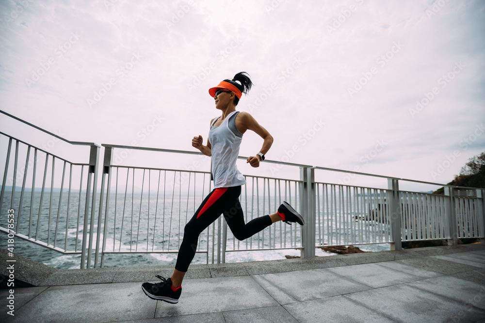 Healthy lifestyle fitness sports woman runner running on seaside trail Healthy lifestyle fitness sports woman runner running on seaside trail